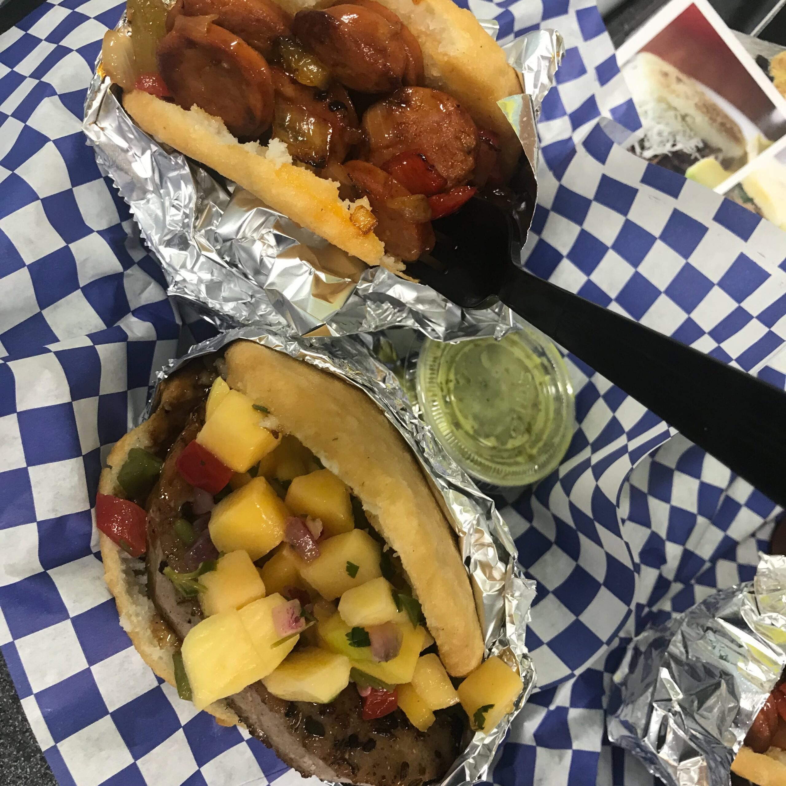 Two arepas filled with sausage and peppers and mango salsa