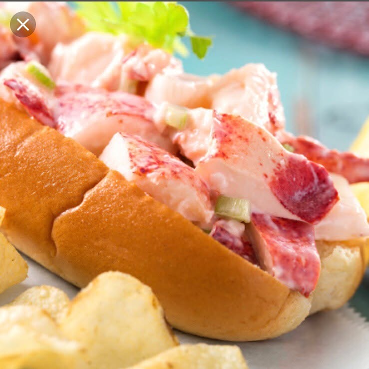 Lobster roll in a toasted bun with potato chips